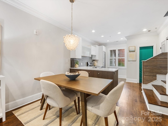dining space featuring ornamental molding, baseboards, a chandelier, dark wood-style floors, and stairway