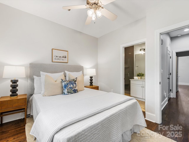 bedroom featuring wood finished floors, baseboards, ensuite bathroom, and ceiling fan