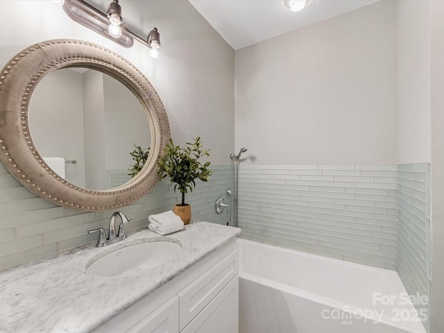 full bath with a bath, tasteful backsplash, and vanity
