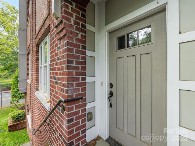 entrance to property featuring brick siding