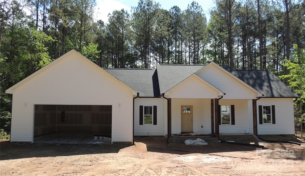 1761 Every Dr, Iron Station, NC 28080 - modern farmhouse with a garage, roof with shingles, dirt driveway, crawl space, and a porch