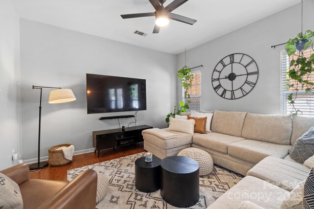 living room featuring a ceiling fan, wood finished floors, plenty of natural light, and baseboards