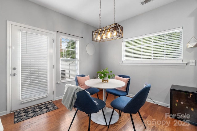 dining room with wood finished floors, baseboards, and a chandelier