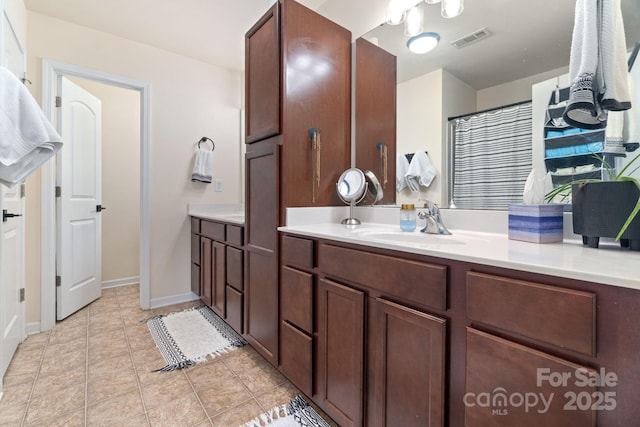 bathroom with vanity, baseboards, and tile patterned floors