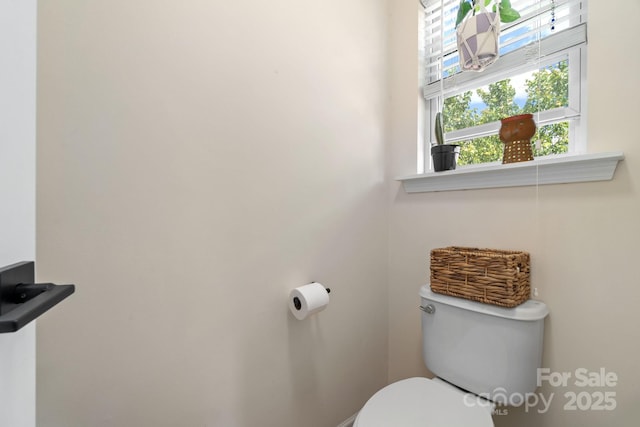 half bath with plenty of natural light and toilet
