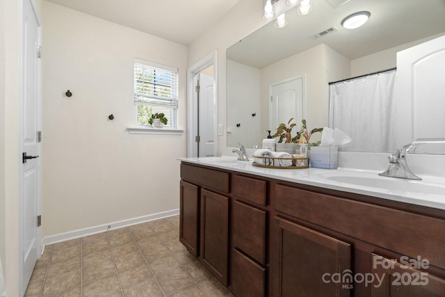 full bath featuring double vanity and baseboards