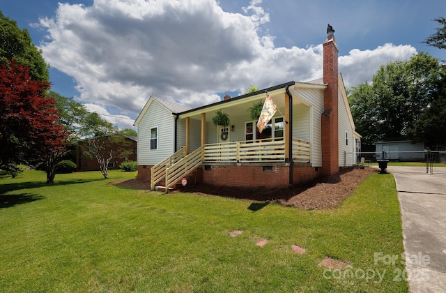view of front of house with a chimney, fence, covered porch, crawl space, and a front yard