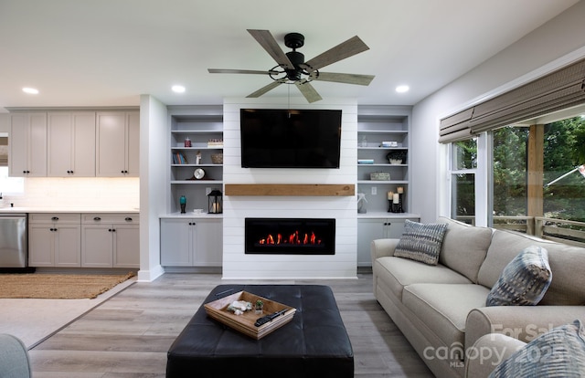 living room featuring a fireplace, light wood-type flooring, a ceiling fan, and recessed lighting