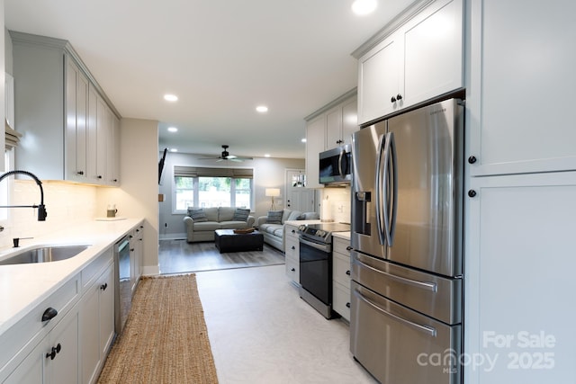 kitchen with a ceiling fan, a sink, appliances with stainless steel finishes, tasteful backsplash, and recessed lighting