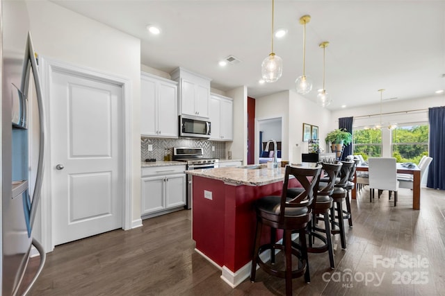 5727 Lavaux Ct, Charlotte, NC 28214 - kitchen with appliances with stainless steel finishes, dark wood-style flooring, a center island with sink, a sink, and recessed lighting