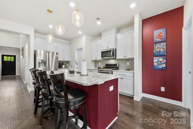 5727 Lavaux Ct, Charlotte, NC 28214 - kitchen featuring stainless steel appliances, decorative backsplash, a breakfast bar, dark wood-type flooring, and recessed lighting