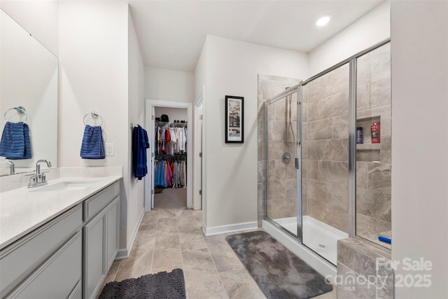 5727 Lavaux Ct, Charlotte, NC 28214 - bathroom featuring a stall shower, vanity, baseboards, and a spacious closet