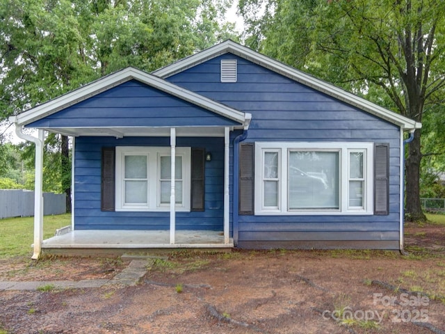 view of front of house featuring covered porch and fence