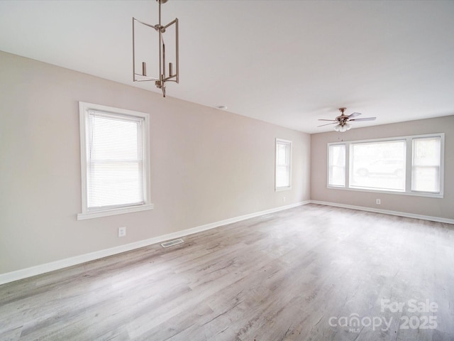 unfurnished room with wood finished floors, baseboards, and a ceiling fan
