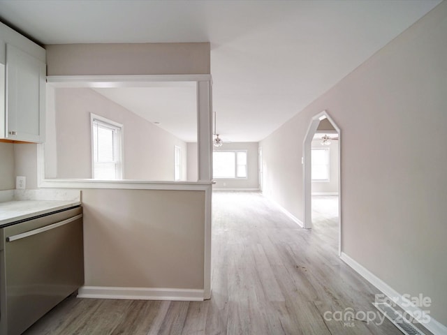 kitchen with dishwasher, white cabinetry, baseboards, light wood finished floors, and light countertops
