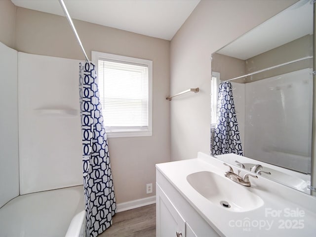 full bathroom featuring wood finished floors, vanity, shower / tub combo, and baseboards