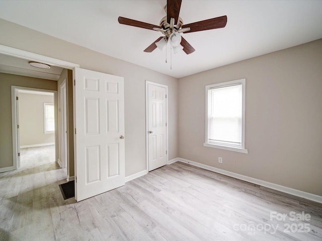 unfurnished bedroom with light wood finished floors, baseboards, and ceiling fan