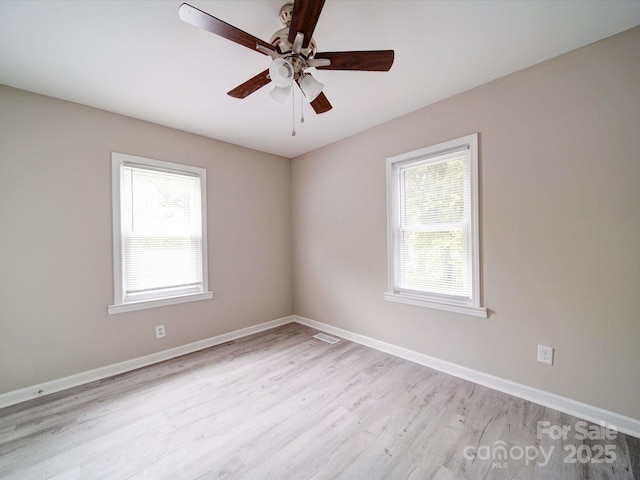unfurnished room featuring healthy amount of natural light, light wood-style flooring, ceiling fan, and baseboards