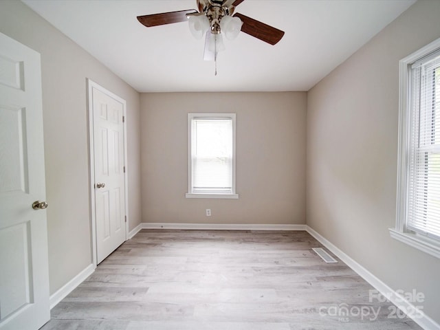 unfurnished bedroom with multiple windows, light wood-type flooring, baseboards, and ceiling fan
