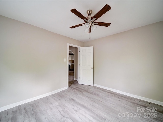 spare room with wood finished floors, baseboards, and ceiling fan