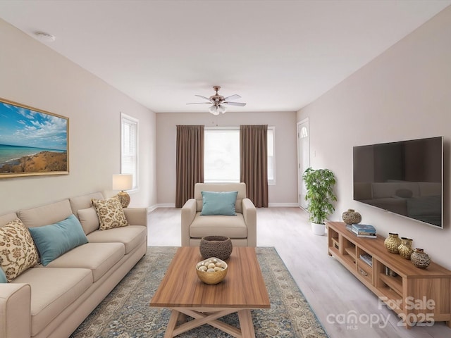 living area featuring healthy amount of natural light, wood finished floors, baseboards, and ceiling fan