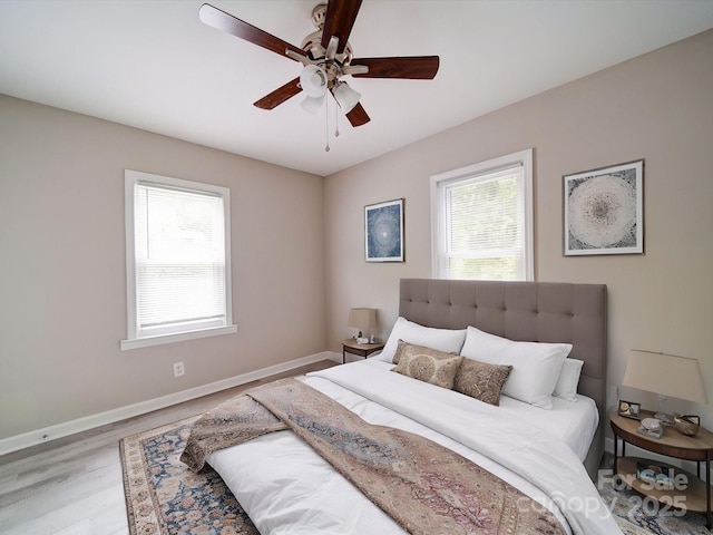 bedroom featuring baseboards, wood finished floors, and ceiling fan
