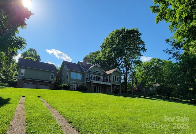 221 Stillwater Rd, Troutman, NC 28166 - back of house with a lawn, a garage, a chimney, and driveway