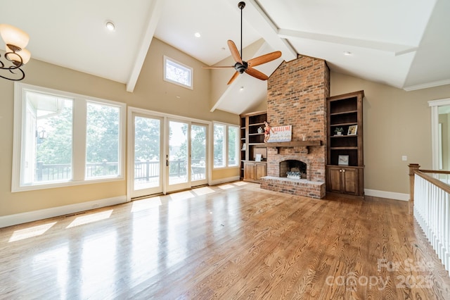 221 Stillwater Rd, Troutman, NC 28166 - unfurnished living room with ceiling fan, light wood-style flooring, beam ceiling, a brick fireplace, and high vaulted ceiling