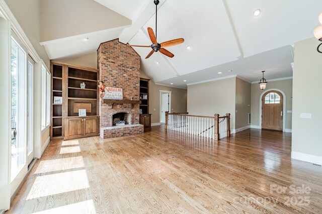 221 Stillwater Rd, Troutman, NC 28166 - unfurnished living room with beamed ceiling, a ceiling fan, light wood finished floors, a brick fireplace, and high vaulted ceiling