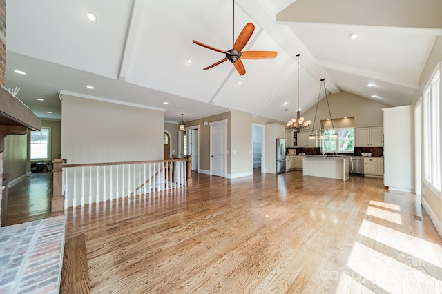 221 Stillwater Rd, Troutman, NC 28166 - unfurnished living room with a chandelier, beamed ceiling, light wood-style floors, ceiling fan, and plenty of natural light