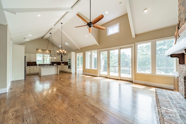 221 Stillwater Rd, Troutman, NC 28166 - unfurnished living room with high vaulted ceiling, a chandelier, beamed ceiling, ceiling fan, and light wood finished floors