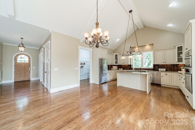 221 Stillwater Rd, Troutman, NC 28166 - kitchen with stainless steel appliances, a chandelier, a center island, light wood finished floors, and decorative backsplash
