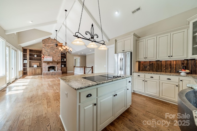 221 Stillwater Rd, Troutman, NC 28166 - kitchen featuring freestanding refrigerator, black electric stovetop, a center island, light wood-type flooring, and light stone counters