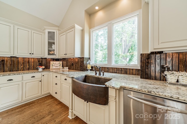 221 Stillwater Rd, Troutman, NC 28166 - kitchen with stainless steel dishwasher, lofted ceiling, light stone countertops, glass insert cabinets, and light wood-type flooring