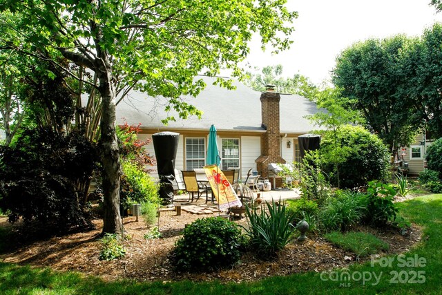 rear view of house featuring a patio and a chimney
