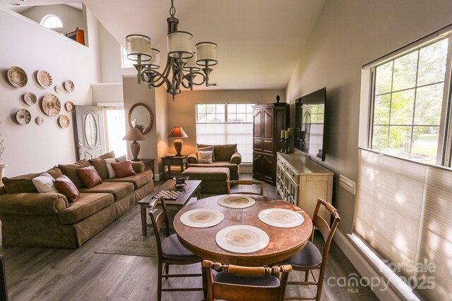 dining area featuring a chandelier, dark wood-style flooring, plenty of natural light, and high vaulted ceiling