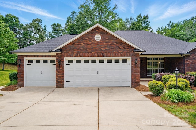 single story home with driveway, brick siding, roof with shingles, and a garage