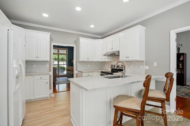 kitchen featuring white fridge with ice dispenser, a peninsula, a sink, under cabinet range hood, and white cabinetry