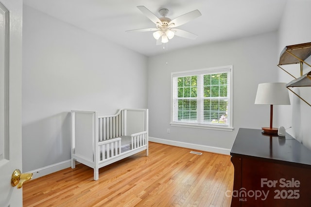 unfurnished bedroom featuring light wood-style floors, baseboards, and a ceiling fan