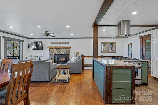 466 Hanging Rock Rd, Mars Hill, NC 28754 - kitchen with green cabinetry, wall chimney range hood, high end stainless steel range, a kitchen island, and ceiling fan