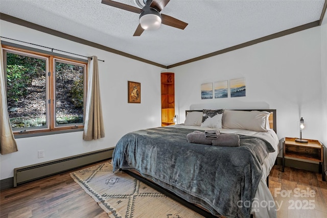 466 Hanging Rock Rd, Mars Hill, NC 28754 - bedroom featuring a baseboard heating unit, wood finished floors, a textured ceiling, ceiling fan, and ornamental molding
