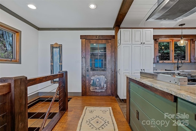 466 Hanging Rock Rd, Mars Hill, NC 28754 - kitchen with range hood, wood finished floors, light stone countertops, decorative backsplash, and white cabinets