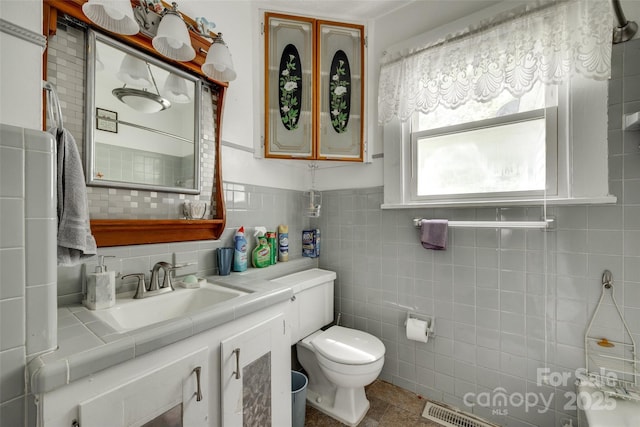 bathroom featuring toilet, tile walls, and vanity