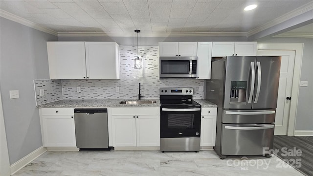 kitchen with appliances with stainless steel finishes, a sink, light marble finish flooring, crown molding, and white cabinets