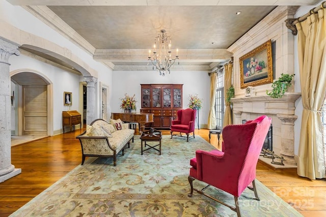 4523 Fox Brook Ln, Charlotte, NC 28211 - living area with ornate columns, wood finished floors, arched walkways, a chandelier, and a fireplace