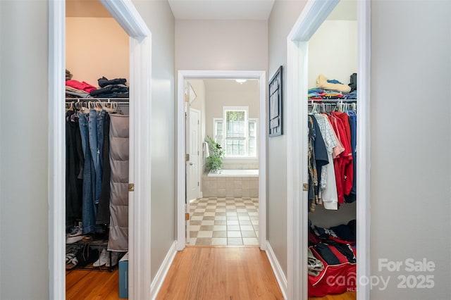 hallway with light wood finished floors and baseboards