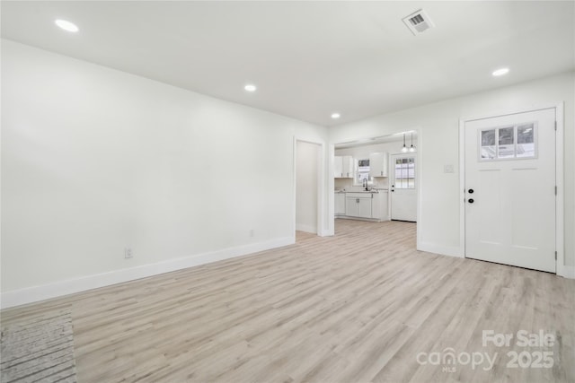 1417 W Monroe St, Salisbury, NC 28144 - unfurnished living room featuring light wood-style floors, baseboards, recessed lighting, and a sink