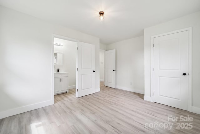 1417 W Monroe St, Salisbury, NC 28144 - unfurnished bedroom with light wood-style floors, baseboards, and connected bathroom