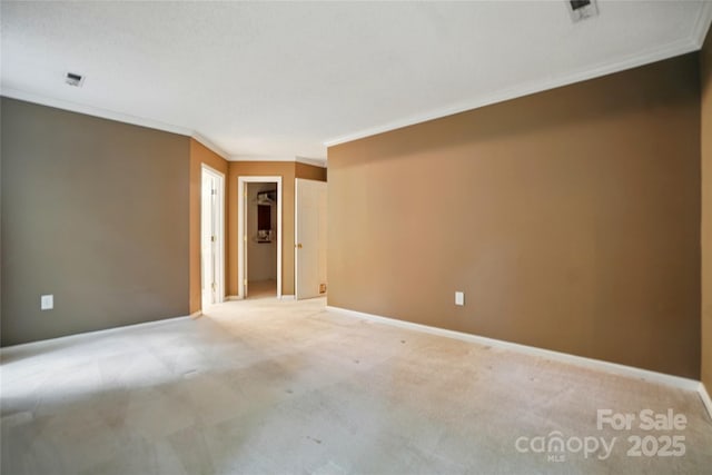 empty room featuring crown molding, light colored carpet, and baseboards