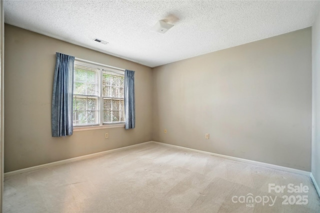 unfurnished room featuring carpet floors, a textured ceiling, and baseboards